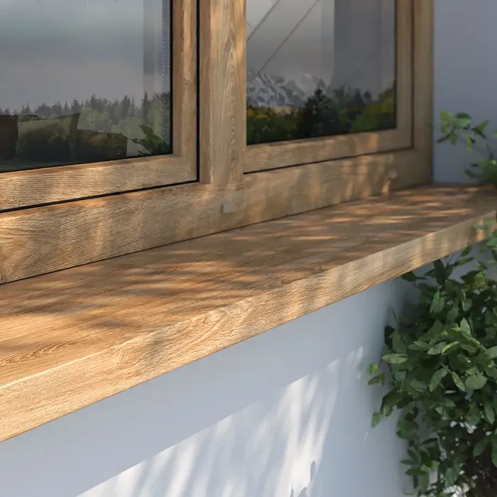 Davanzale esterno in decorazione effetto legno, installato sotto una finestra in legno su una facciata chiara.