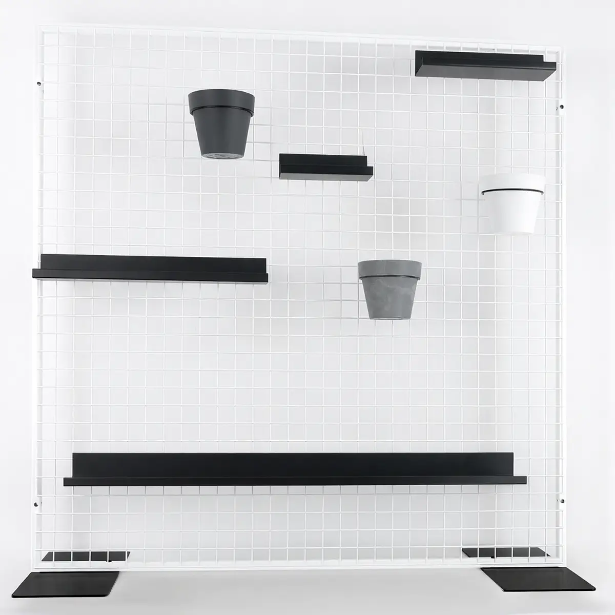 Griglia espositiva bianca con mensole e vasi &ndash; esempio di sistema di accessori per la configurazione di un pannello loft.