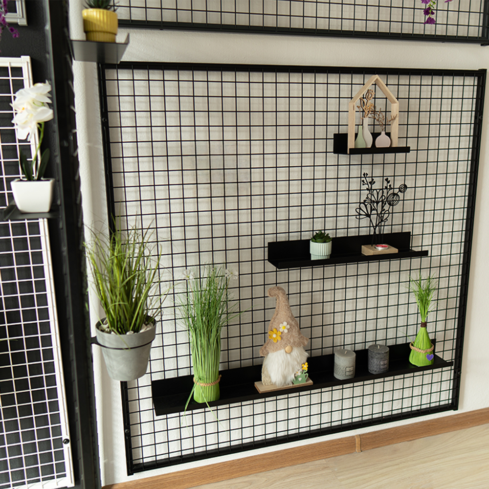 Griglia loft con mensole espositive nere decorate con piante, vasi e accessori da interno.